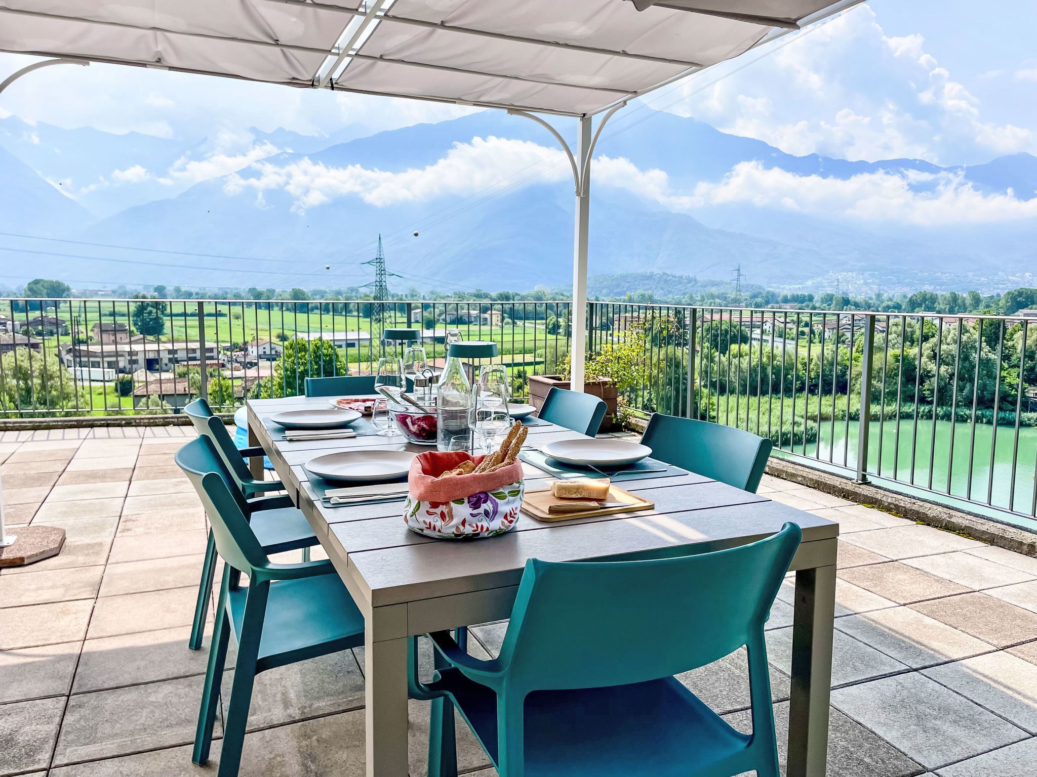 Ein Essbereich im Freien mit einem Tisch für zwei Personen mit Blick auf eine malerische Berg- und Flusslandschaft.
