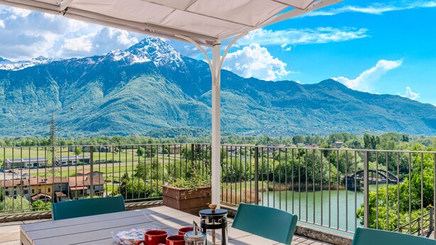 A terrace with a table set for two, overlooking a river and mountains. - Apartment Flat 1 by Interhome (Sorico Albonico)