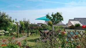 A garden with various flowers and a wooden fence.