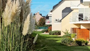 Een woonwijk met huizen, een verzorgd gazon en hoge siergrassen.