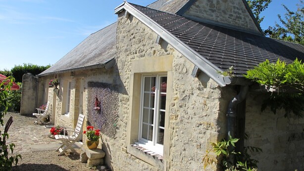 A stone house with a sloped roof, a chimney, and a window with a white frame. - Les Lutins by Interhome (Commes)