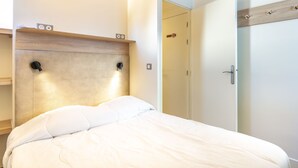 Ein modernes Schlafzimmer mit Bett, Holz-Kopfteil, Nachttisch und Kleiderschrank.