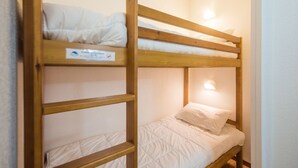 Una cama litera con un cartel en la cama superior.