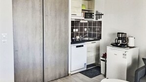 A compact kitchen with a microwave, coffee machine, and a small refrigerator. - La Dune by Interhome (Valras Plage)