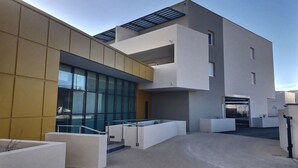 A modern building with a flat roof, large windows, and a concrete courtyard. - La Dune by Interhome (Valras Plage)