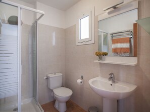 Ein Badezimmer mit Toilette, Waschbecken und Dusche.