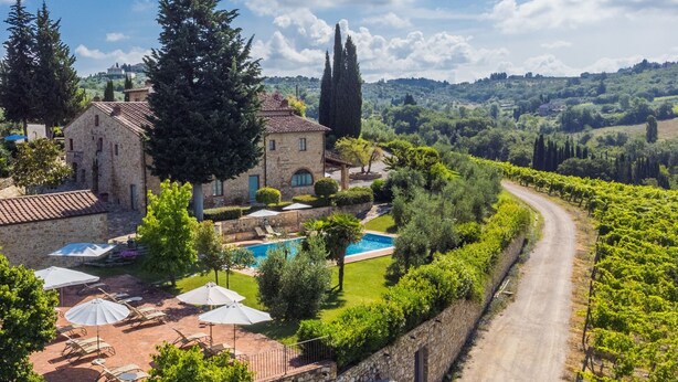 Une villa avec piscine, espace extérieur aménagé et vue sur les vignes.
