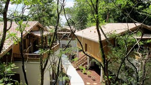 Ein holzhüttenartiges Hotel mit mehreren Zimmern, einer überdachten Außenbereiches und einer Lage im naturbelassenen Wald.