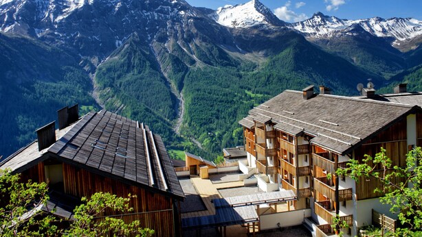 A mountain lodge with wooden architecture, multiple balconies, and a view of snow-capped mountains. - Etoiles d'Orion by Interhome (Orcières-Merlette)