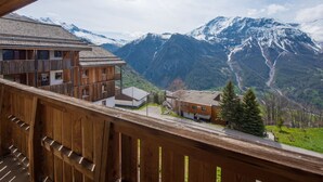 A wooden balcony overlooking a mountainous landscape with snow-capped peaks and a valley below. - Etoiles d'Orion by Interhome (Orcières-Merlette)