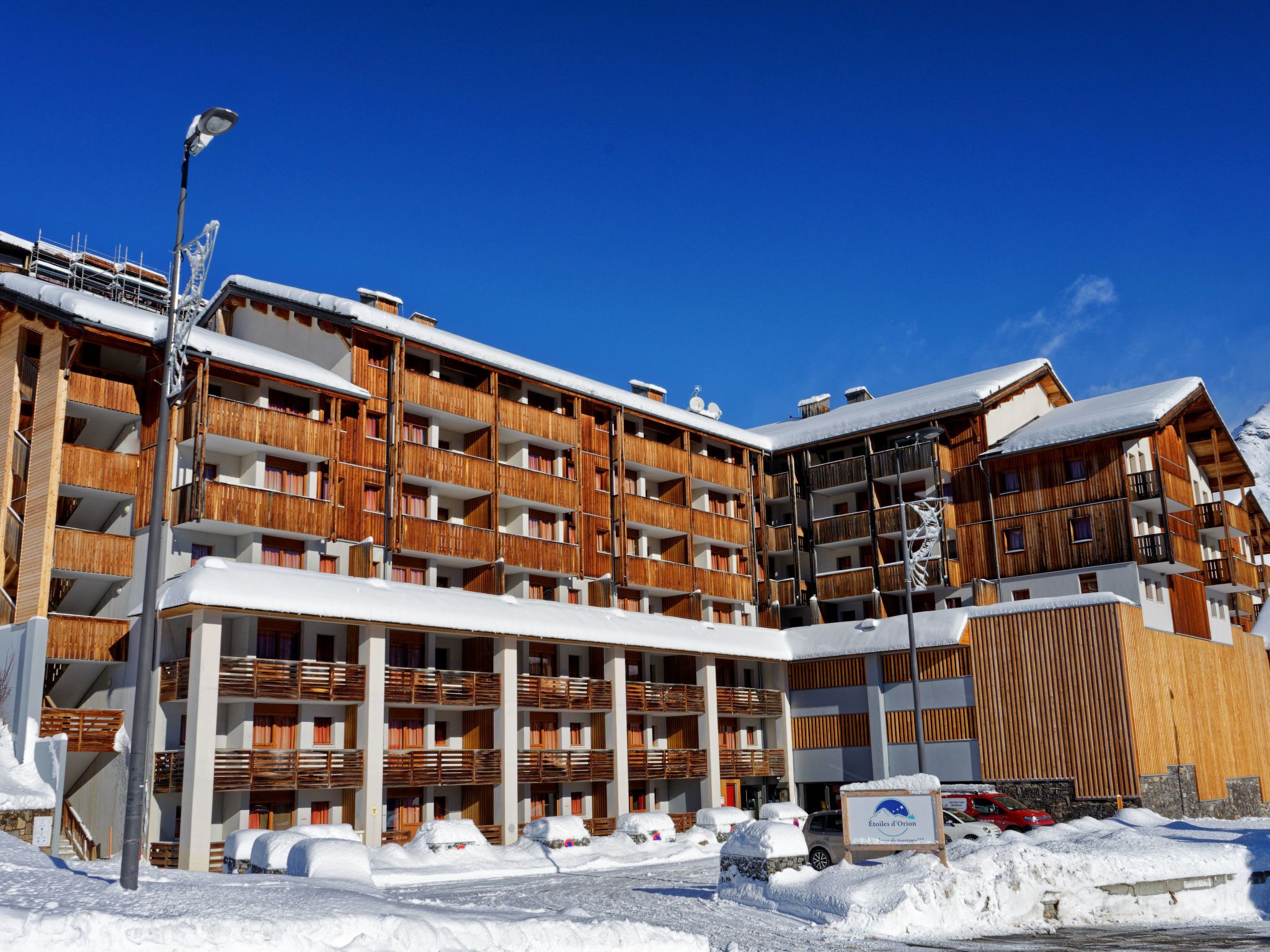 A multi-story hotel with wooden balconies and a covered entrance.