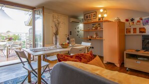 A compact living space with a dining area, a sofa, a kitchen, and a balcony. - La Rondine (LUU280) by Interhome (Lucca)
