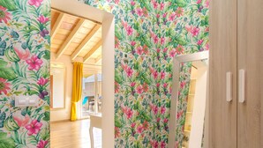 A hallway with floral wallpaper, wooden flooring, and a sliding glass door leading to a balcony. - Apartment Yoko by Interhome (Ses Salines)