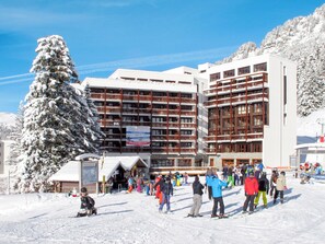 A multi-story hotel with a ski resort in the background.