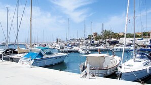 A marina with numerous boats docked, a clear sky, and a distant building. - Vacation home Marina by Interhome (Sa Rápita)