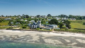 A coastal property with a large house, a beach, and a residential area in the background. - Odalys Domaine des Roches Jaunes by Interhome (Plougasnou)