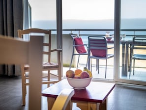 Un coin repas avec une table, des chaises et un saladier rempli de fruits.