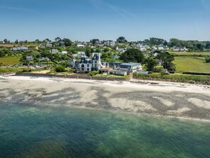 A coastal property with a large house, a beach, and a residential area in the background. - Odalys Domaine des Roches Jaunes by Interhome (Plougasnou)