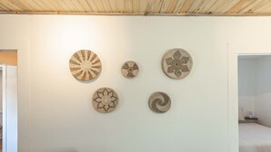 Een kamer met een bed, een klein tafeltje en een stoel. Er zijn vijf ronde decoraties aan de muur.
