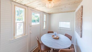Een eethoek met een ronde tafel, vier stoelen en een decoratief middelpunt.