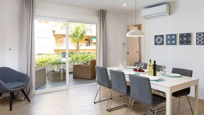 Un comedor con una mesa dispuesta para cuatro personas, un sofá y una silla.