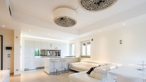 A modern kitchen with white cabinetry, a central island, and bar stools. - Appendino by Interhome (Asti)