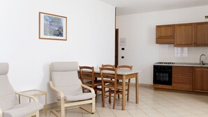Een moderne keuken met houten kastjes en een eethoek met twee stoelen en een tafel.