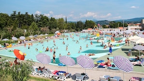A large outdoor swimming pool with multiple lanes, surrounded by sun loungers and umbrellas. - Cisano & San Vito by Interhome (Bardolino)