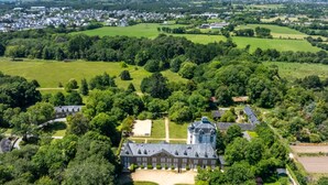 An aerial view of a large estate with a prominent building featuring a tower, surrounded by lush greenery and fields. - Odalys Référence Le Château de Kéravéon by Interhome (Erdeven)