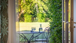 An outdoor patio with a table and chairs, a vase, and two glasses. - Odalys Référence Le Château de Kéravéon by Interhome (Erdeven)