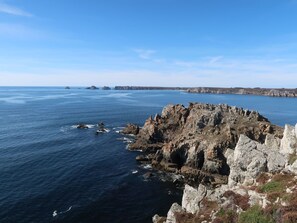 A coastal landscape with rocky cliffs and calm sea.