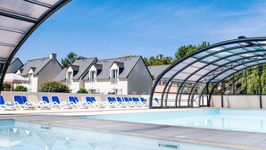 A swimming pool with lounge chairs and a covered area. - Rés. Odalys Référence Horizon Morgat by Interhome (Crozon-Morgat)