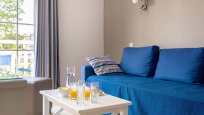 A room with a bed, a table with breakfast items, and a window with curtains. - Odalys Référence Le Domaine des Dunettes by Interhome (Cabourg)