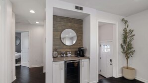 A modern kitchen with white cabinetry, a built-in oven, and a round mirror above the countertop. - Cozy, Beautiful Birmingham 4BR/2BA Getaway! (Birmingham)
