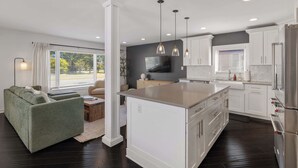 A modern kitchen with white cabinets, a central island, and pendant lighting. - Cozy, Beautiful Birmingham 4BR/2BA Getaway! (Birmingham)