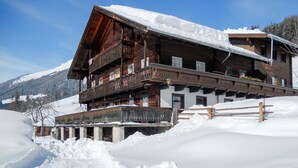 Una cabaña de madera con balcones, rodeada de nieve.