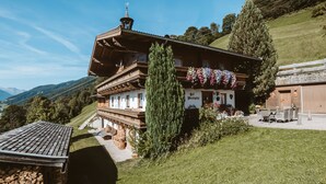 En traditionel schweizisk chalet med skrå tag, træbalkoner og en blomsterpyntet indgang.