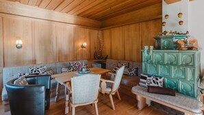 Un intérieur en bois comprenant un coin repas, des bancs et un meuble vert.