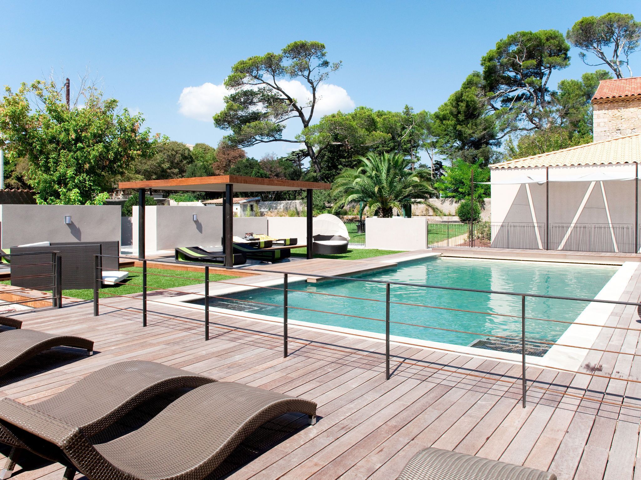 A swimming pool with lounge chairs and a pergola.