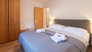A bedroom with a bed, a wardrobe, and a nightstand.