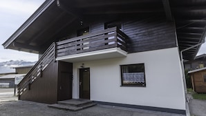 A two-story building with a balcony, a door, and a small window.