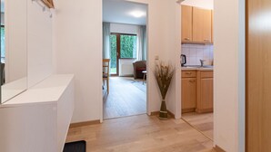 A modern apartment with a kitchen, dining area, and a living room with a large window.