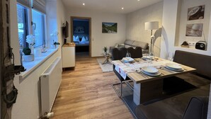 A modern kitchen with a dining area, a sofa, and a TV. - Stefanie by Interhome (Bruck)