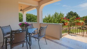 A covered patio with a table and chairs, potted plants, and a view of greenery. - Vacation home Ana by Interhome (Labin)