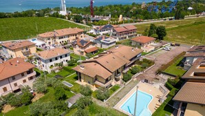 Vista aérea de una zona residencial con casas, una piscina y una masa de agua al fondo.