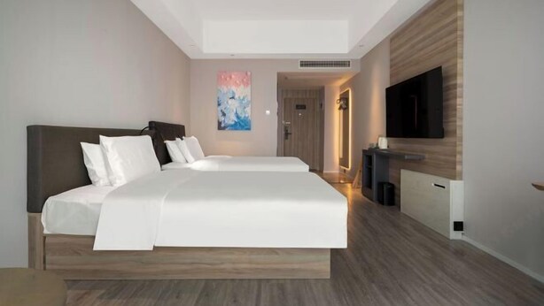 A modern hotel room with a large bed, a flat-screen TV, and a minimalist design. - HanTing Hotel (Xiamen Airport Wuyuan Bay) (Xiamen)