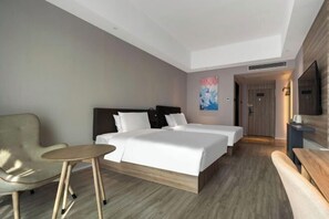 A hotel room with a bed, two bedside tables, a chair, a TV, and a painting on the wall. - HanTing Hotel (Xiamen Airport Wuyuan Bay) (Xiamen)