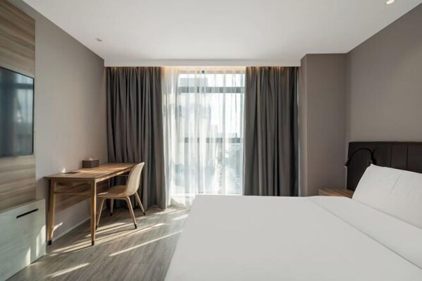 A modern hotel room with a large bed, a desk, and a chair. - HanTing Hotel (Xiamen Airport Wuyuan Bay) (Xiamen)