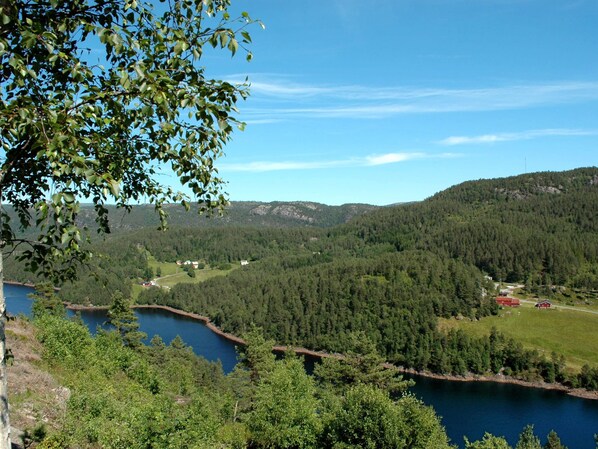 A lake surrounded by dense forest and hills.