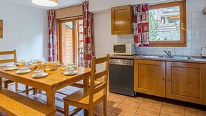 A kitchen with wooden cabinets, a microwave, and a dishwasher. - La Cascade by Interhome (Vaujany)